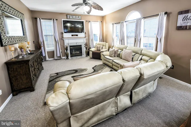 a living room with furniture a flat screen tv and a fireplace
