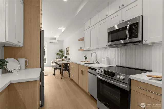 a kitchen with stainless steel appliances a stove a microwave a sink and cabinets