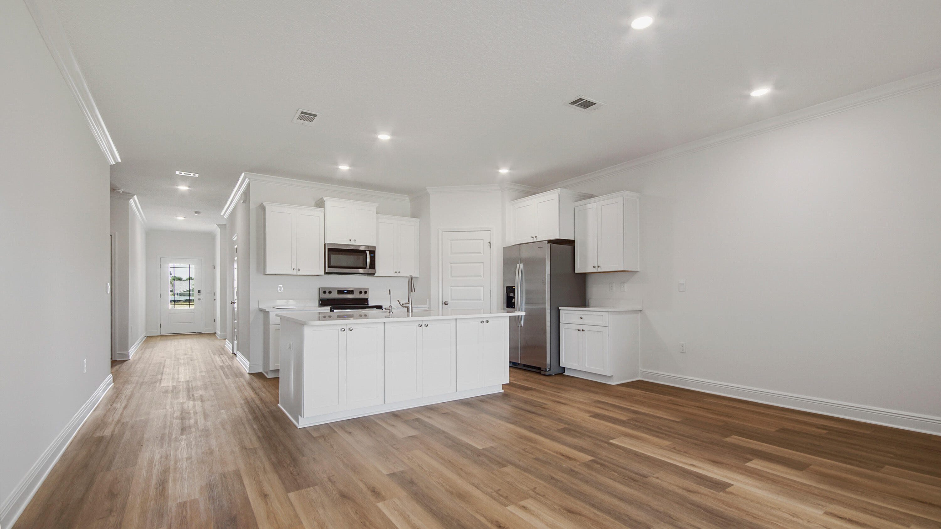71 Gray Owl Drive Freeport, FL 32439 - Photo 20 of 33 a kitchen with stainless steel appliances kitchen island wooden floors and white cabinets