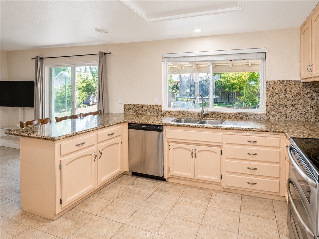 4100 Ahwahnee Court Modesto, CA 95356 - Photo 18 of 34 Kitchen with granite counters, breakfast bar, and backyard views.