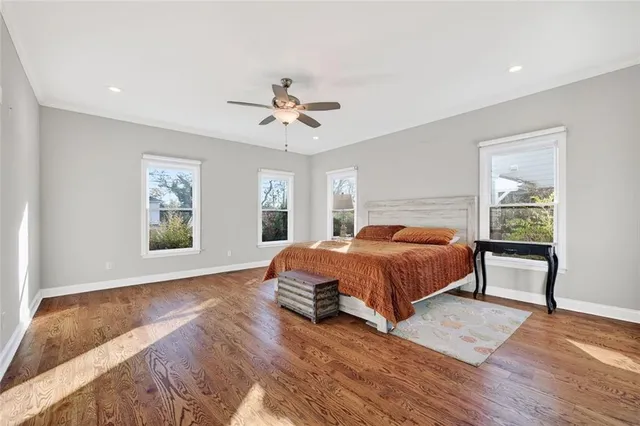 a spacious bedroom with a large bed a chandelier and windows