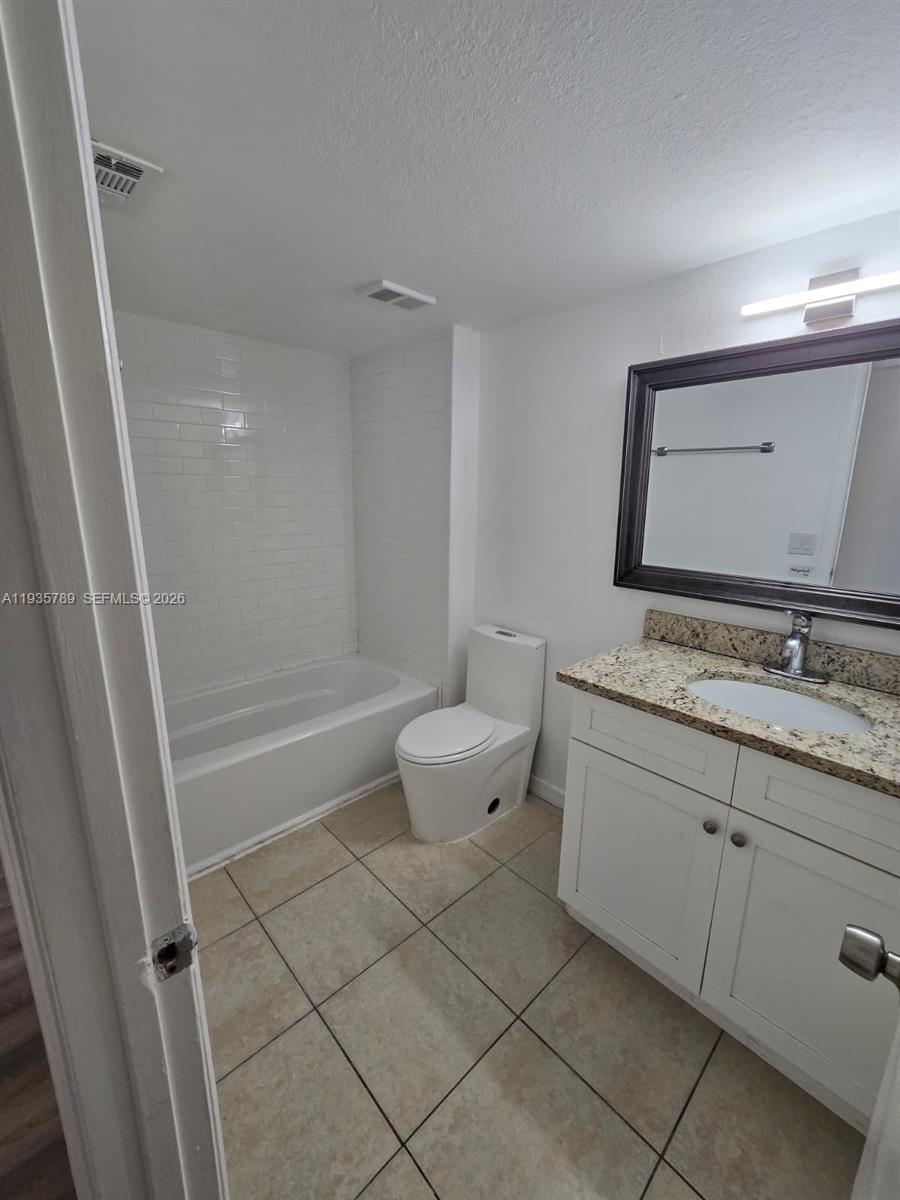4518 Commander Drive, Unit 1928 Orlando, FL 32822 - Photo 13 of 16 a bathroom with a granite countertop sink a toilet and a shower