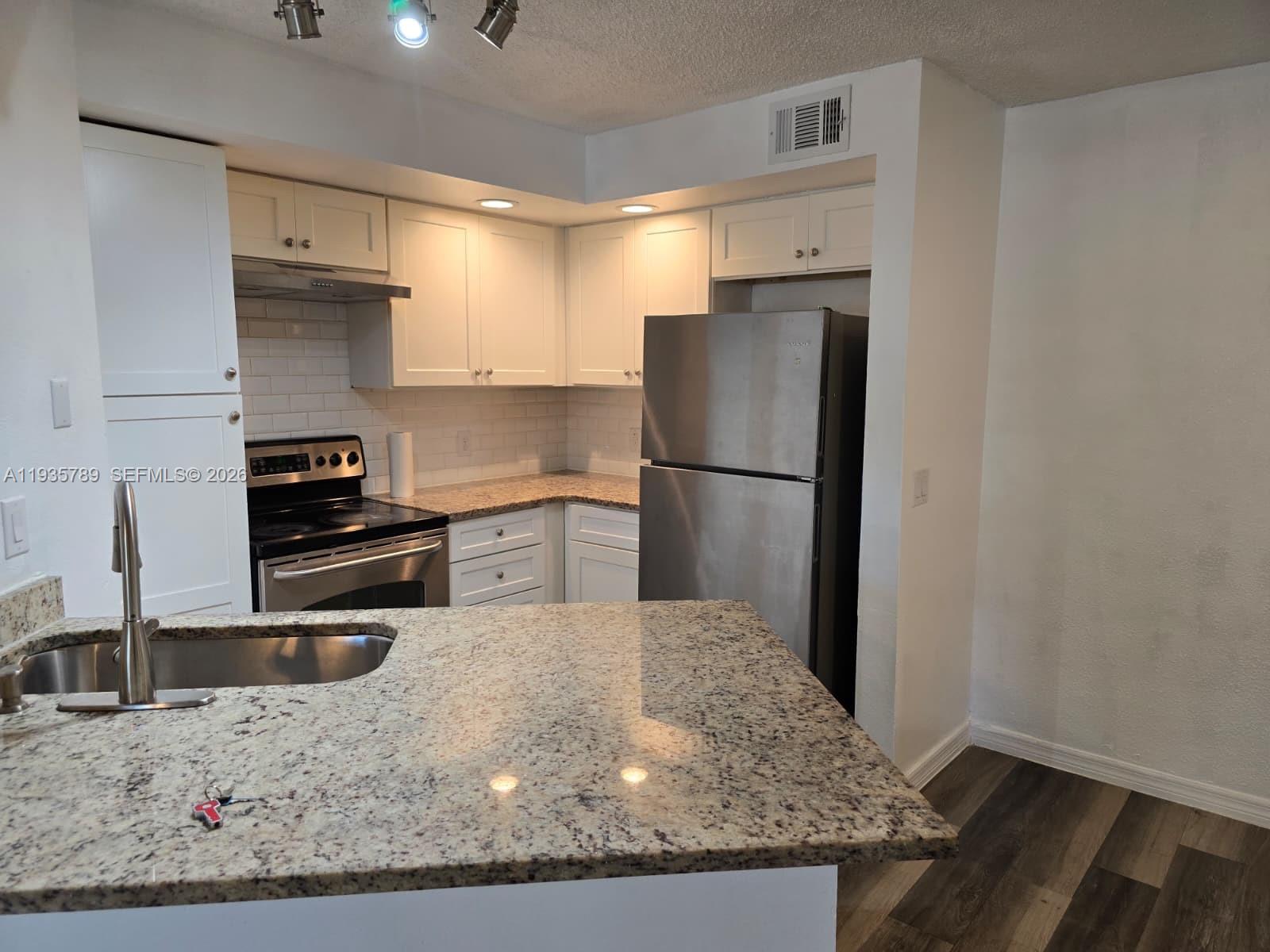4518 Commander Drive, Unit 1928 Orlando, FL 32822 - Photo 15 of 16 a kitchen with a refrigerator and a sink