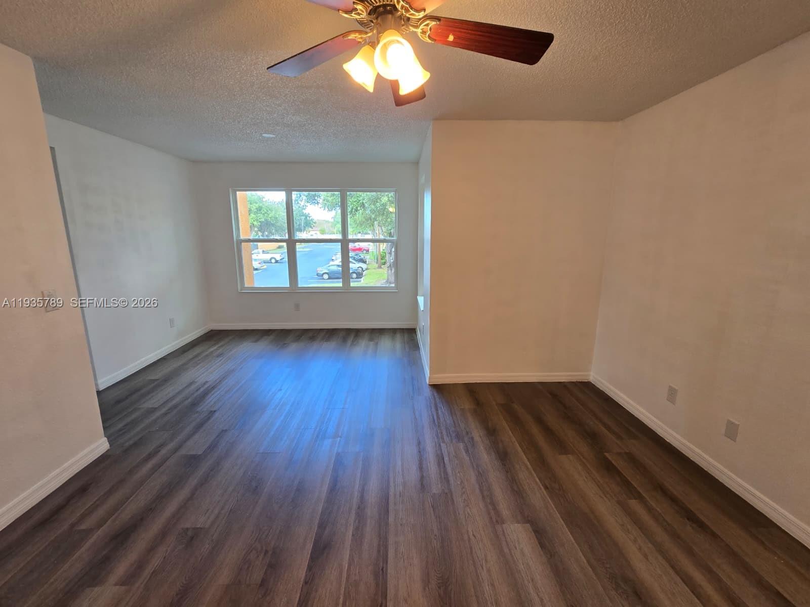 4518 Commander Drive, Unit 1928 Orlando, FL 32822 - Photo 5 of 16 an empty room with wooden floor and windows