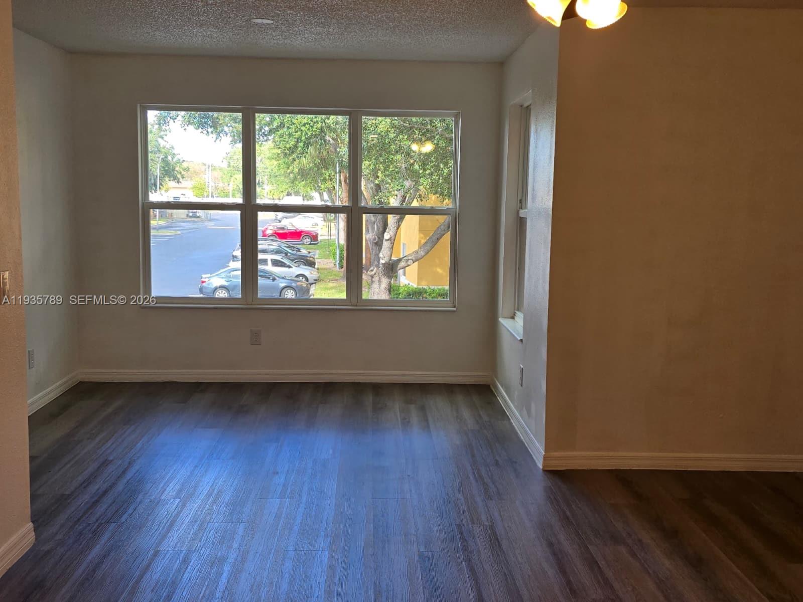 4518 Commander Drive, Unit 1928 Orlando, FL 32822 - Photo 6 of 16 an empty room with wooden floor and windows
