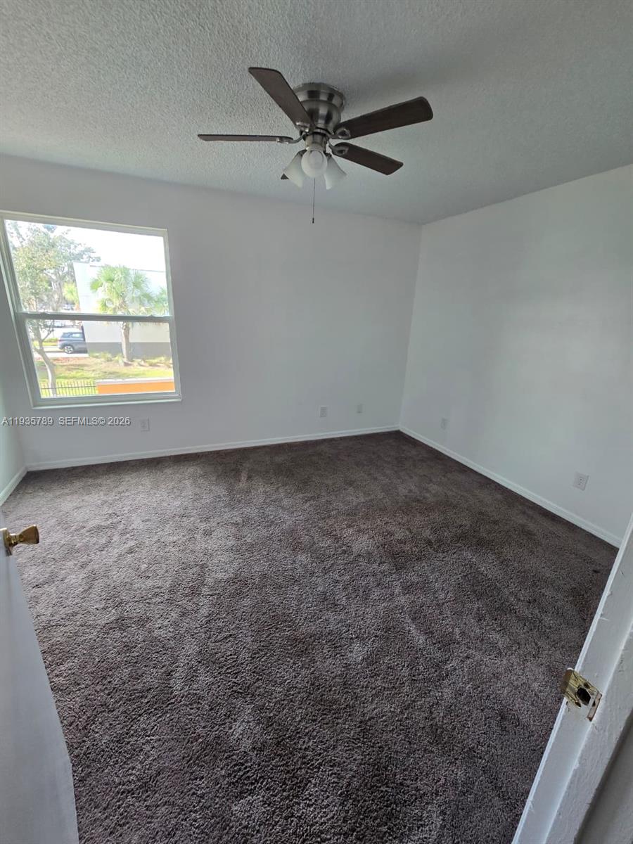4518 Commander Drive, Unit 1928 Orlando, FL 32822 - Photo 10 of 16 an empty room with a ceiling fan and window