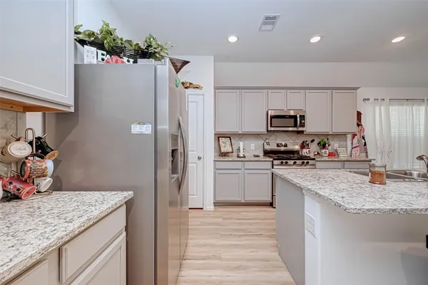 a kitchen with stainless steel appliances granite countertop a stove a sink and a microwave