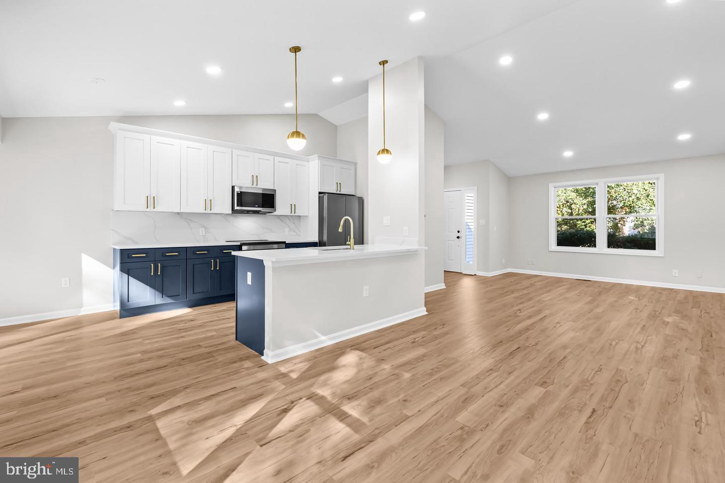10290 South Grant Avenue Manassas, VA 20110 - Photo 11 of 41 a view of kitchen with kitchen island a sink wooden floor and a counter top space
