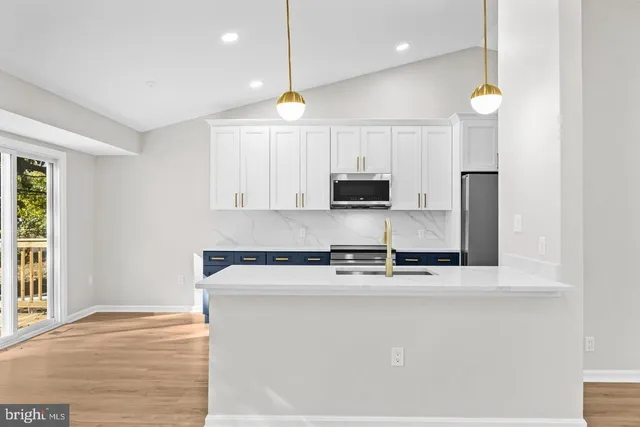 a kitchen with stainless steel appliances granite countertop a sink a stove and a refrigerator