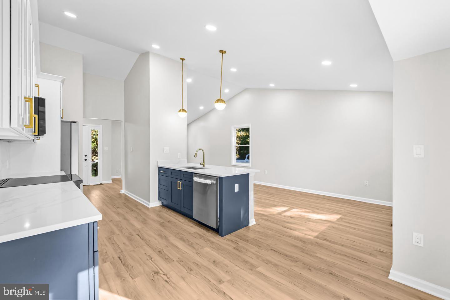 10290 South Grant Avenue Manassas, VA 20110 - Photo 15 of 41 a large room with kitchen island a sink a stove and wooden floor