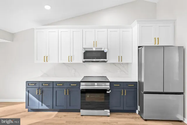 a kitchen with granite countertop white cabinets and stainless steel appliances