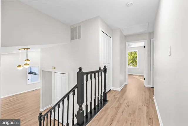 a view of a hallway with wooden floor and stairs