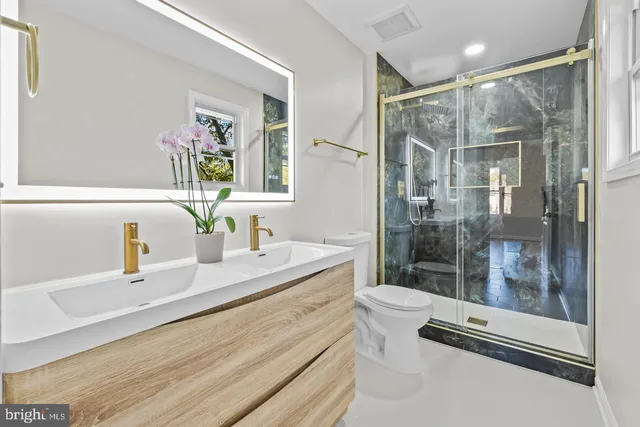 a bathroom with a double vanity sink mirror and shower