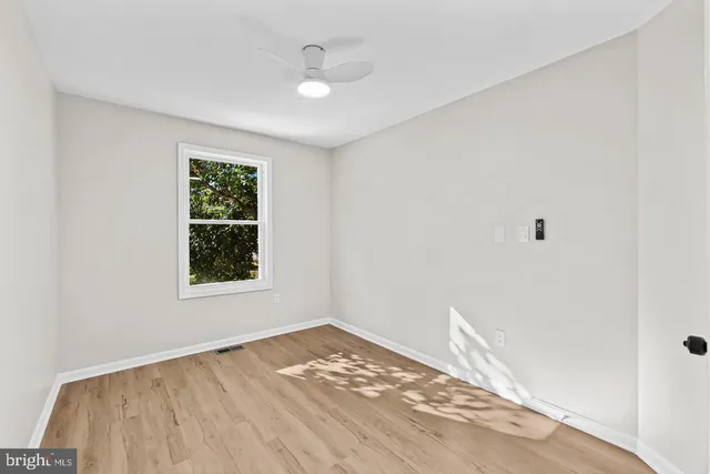 a view of empty room with wooden floor