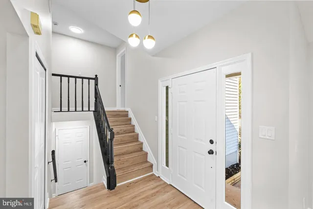 a view of a hallway with wooden floor and staircase
