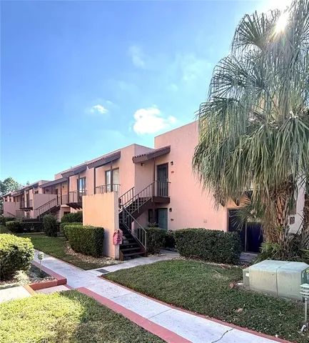 a front view of a house with a yard and potted plants