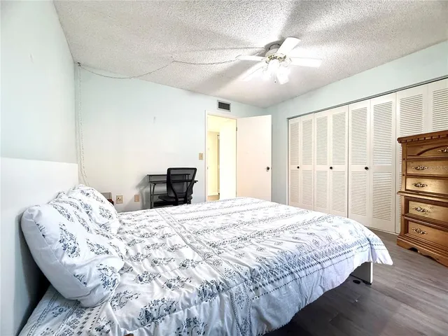 a bedroom with a bed and a chair with the wooden floor
