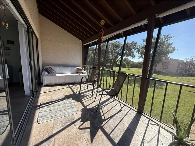a view of a porch with wooden floor and furniture