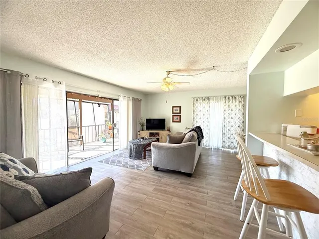 a living room with fireplace furniture and a large window