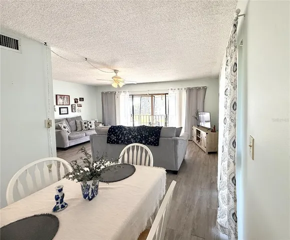 a living room with furniture two couches and a large mirror with wooden floor