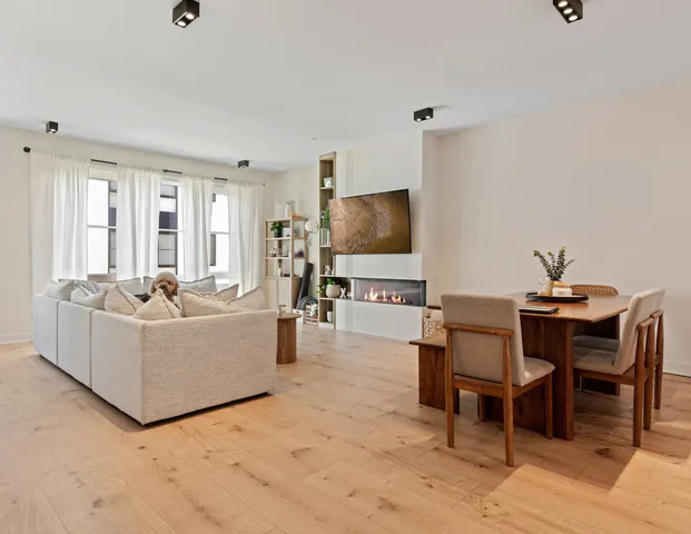 a living room with furniture a flat screen tv and large window
