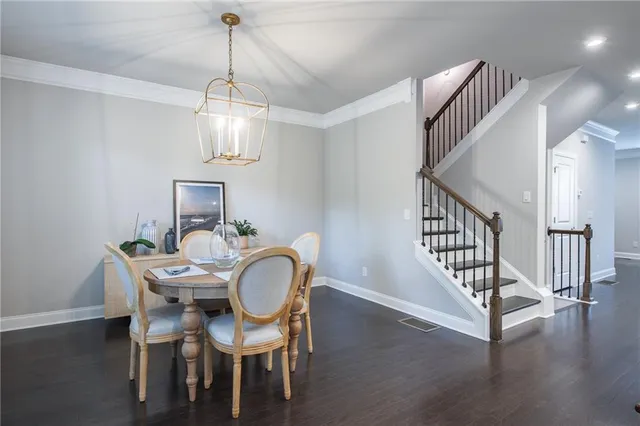 a view of a dining room with furniture a chandelier and wooden floor