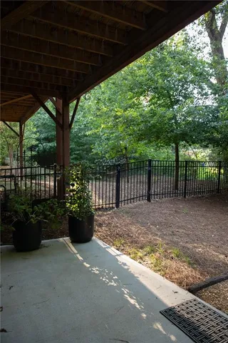 a view of a backyard with floor to ceiling window and wooden fence