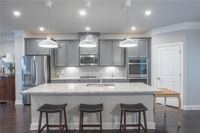 a large kitchen with granite countertop a table and chairs in it