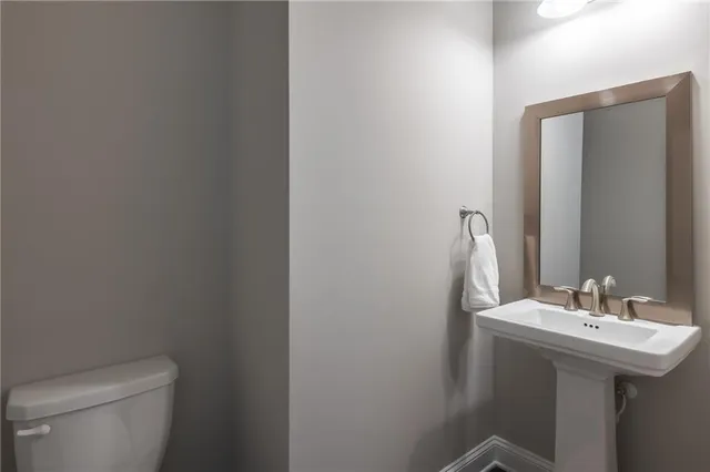 a bathroom with a sink a toilet and mirror