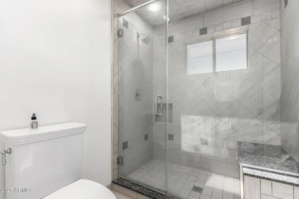 a bathroom with a sink mirror toilet and shower