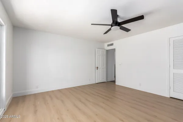 a view of a room with wooden floor and ceiling fan