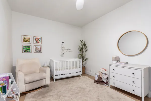 a bedroom with a baby bed couch and a dresser