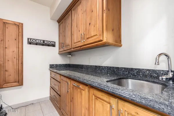 a kitchen with granite countertop a sink a stove and cabinets