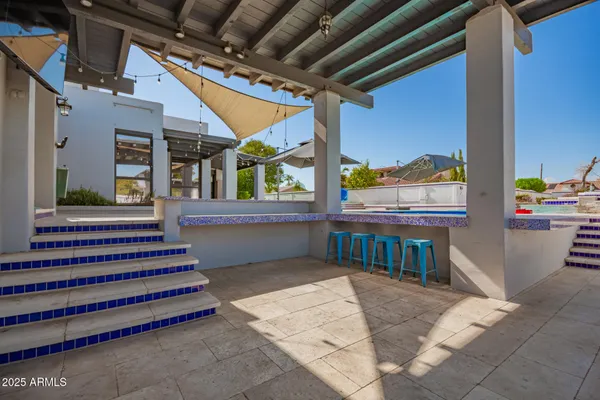 a view of a patio with table and chairs under an umbrella