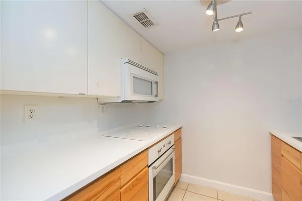 a kitchen with white cabinets and sink