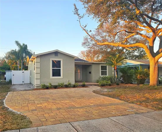 a front view of a house with a yard and potted plants