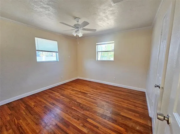 a view of empty room with wooden floor
