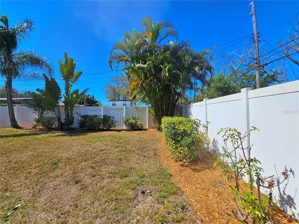 a view of a house with a yard and potted plants
