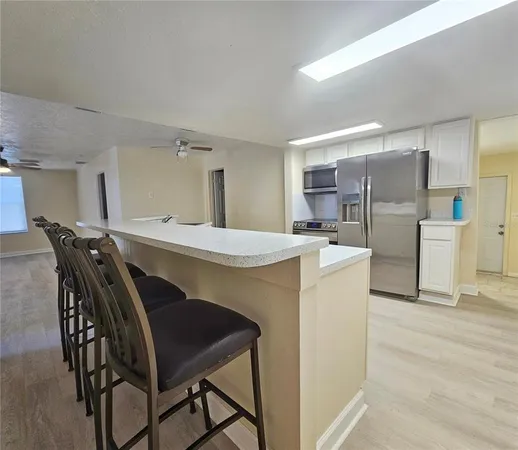 a kitchen with stainless steel appliances a table and chairs