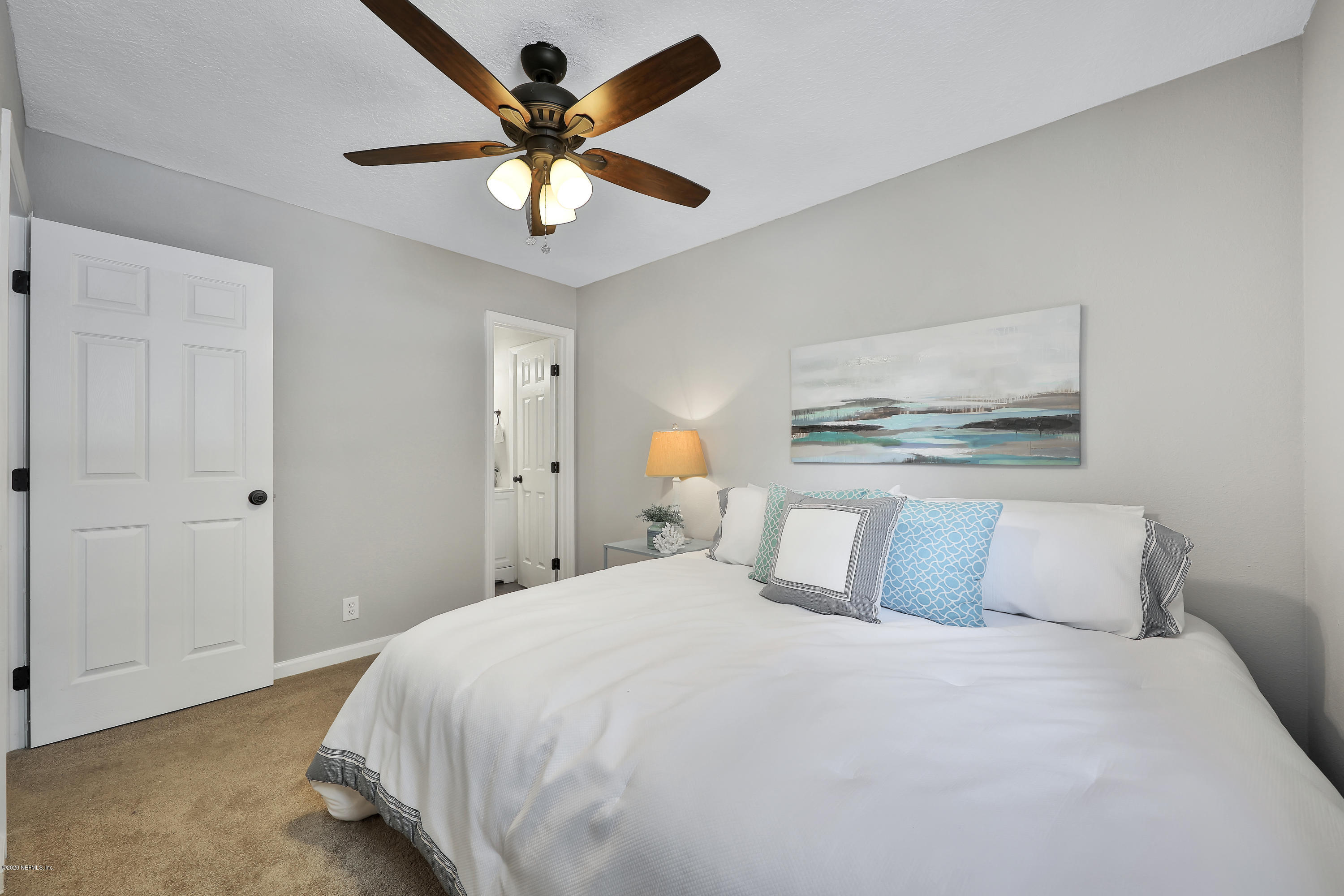 7359 Sandhurst Road South Jacksonville, FL 32277 - Photo 19 of 34 a bedroom with a large bed and a chandelier