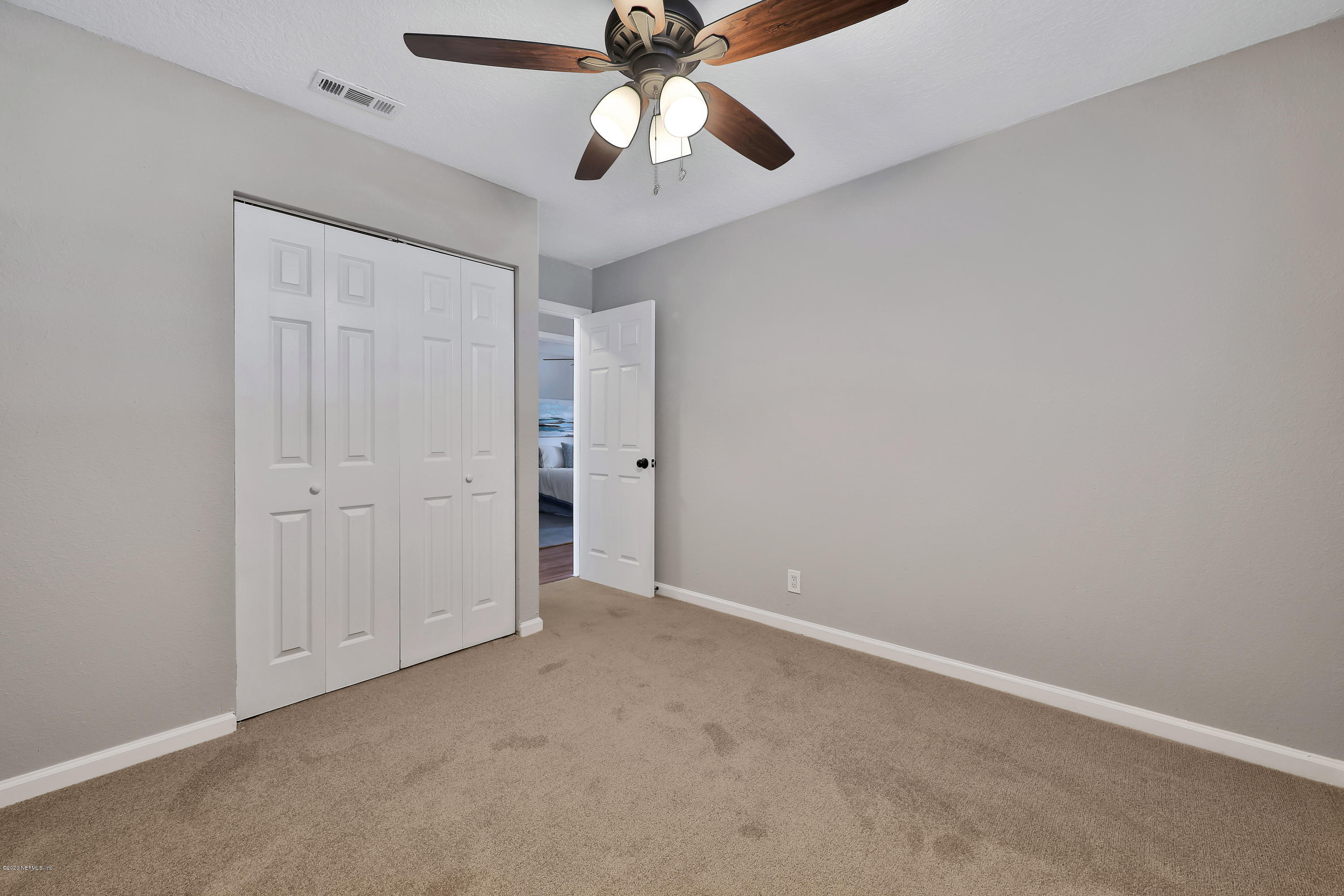 7359 Sandhurst Road South Jacksonville, FL 32277 - Photo 22 of 34 an empty room with closet and a chandelier fan
