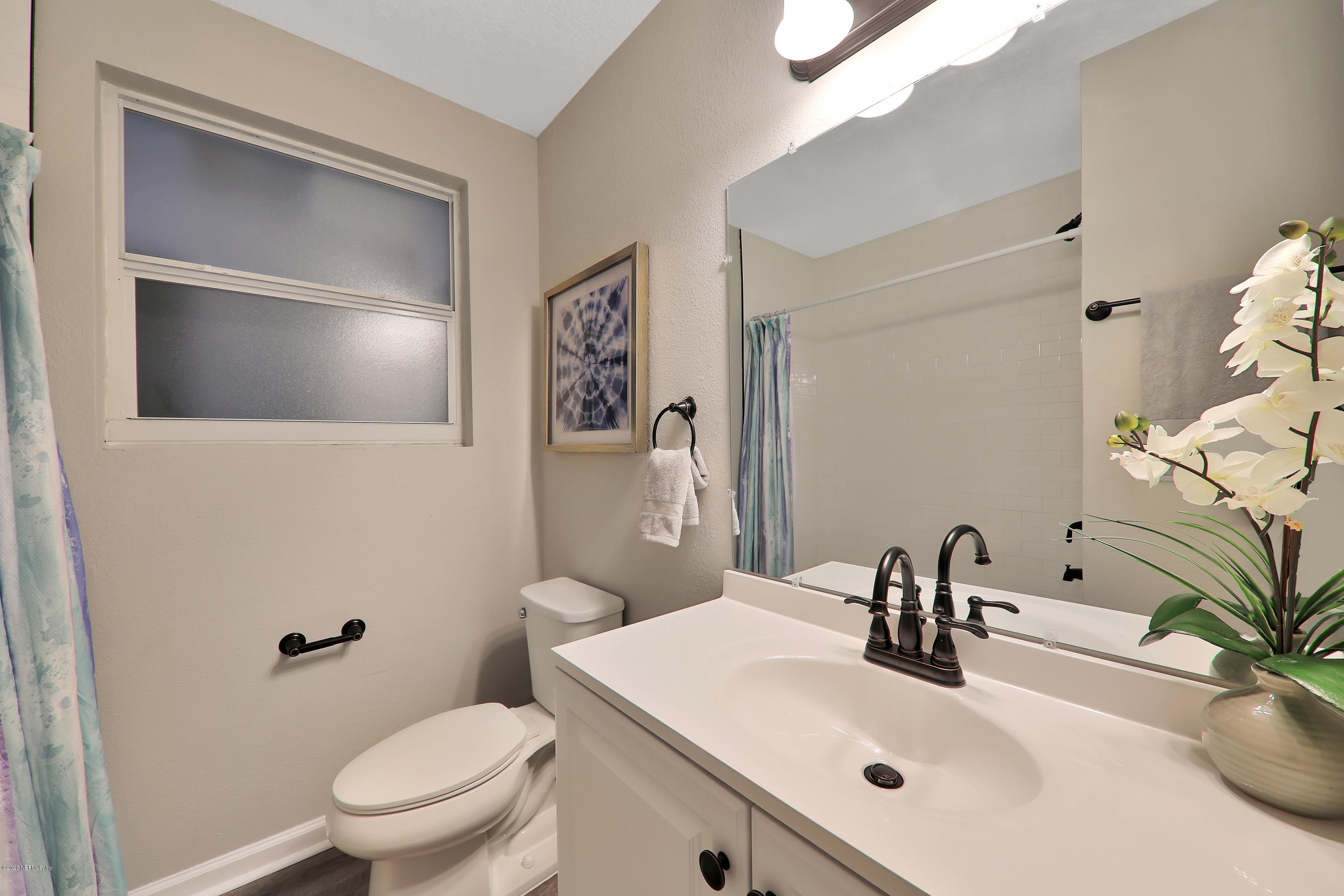 7359 Sandhurst Road South Jacksonville, FL 32277 - Photo 24 of 34 a bathroom with a sink a toilet and mirror
