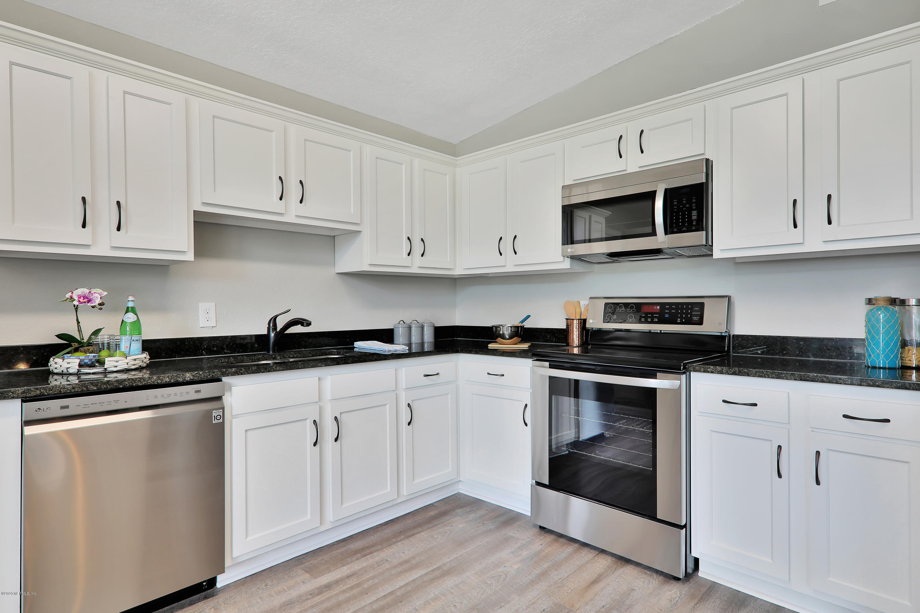 7359 Sandhurst Road South Jacksonville, FL 32277 - Photo 10 of 34 a kitchen with white cabinets and stainless steel appliances