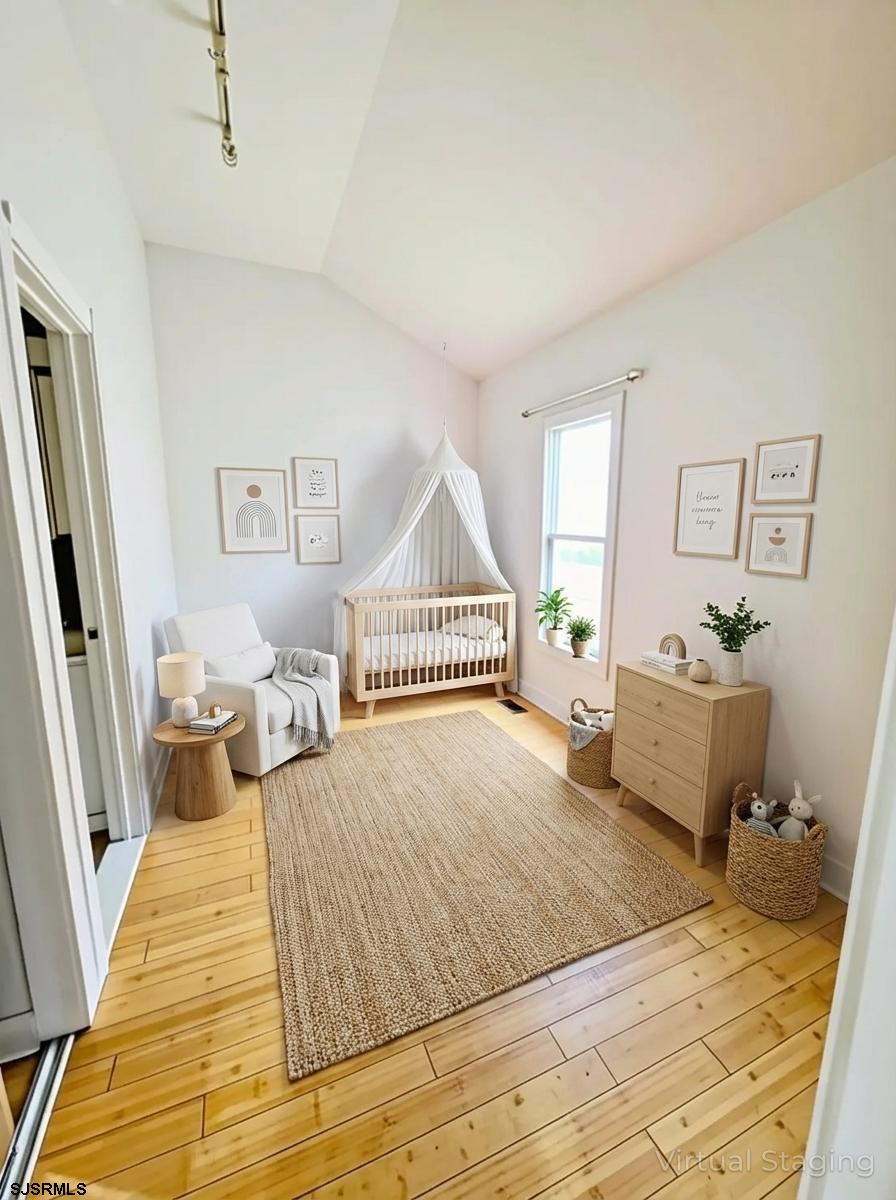 711 Wisteria Road Chelsea Heights, NJ 08401 - Photo 14 of 26 a bedroom with a bed and wooden floor