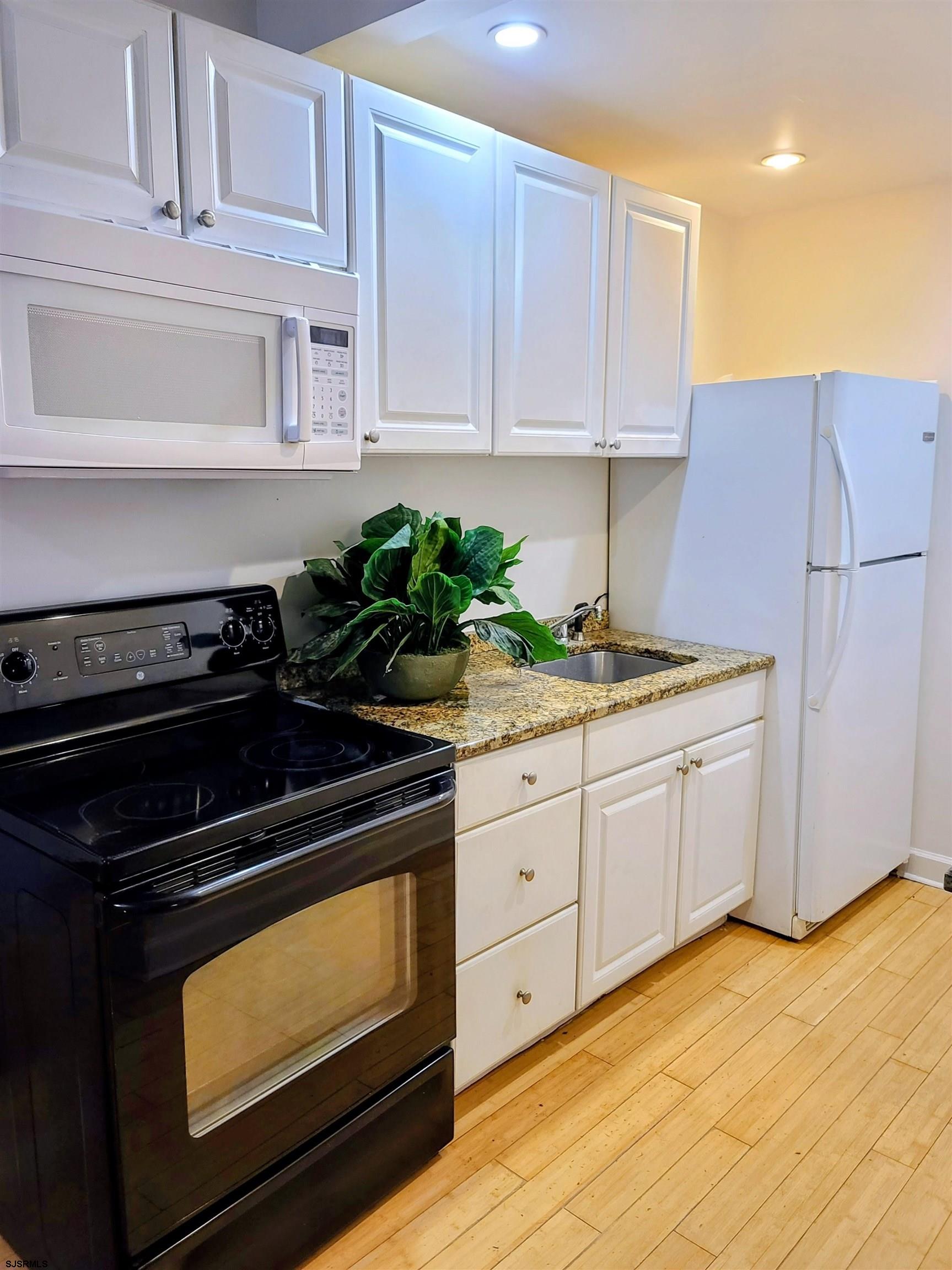 711 Wisteria Road Chelsea Heights, NJ 08401 - Photo 3 of 26 a kitchen with granite countertop white cabinets and stainless steel appliances