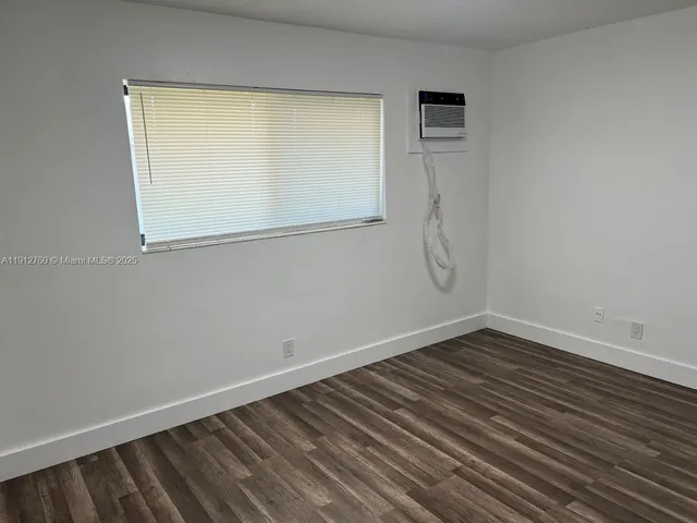 a view of a room with wooden floor and windows
