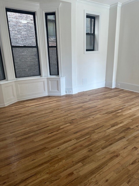 210 5th Avenue, Unit SUITE1102 Manhattan, NY 10010 - Photo 4 of 5 a view of an empty room with wooden floor and a window