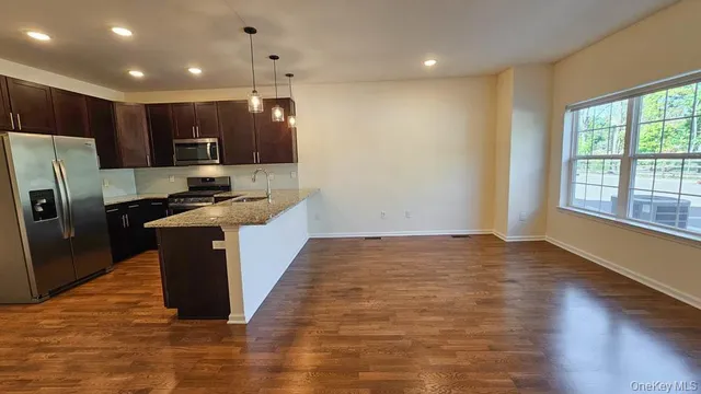a kitchen with kitchen island stainless steel appliances a sink stove and refrigerator