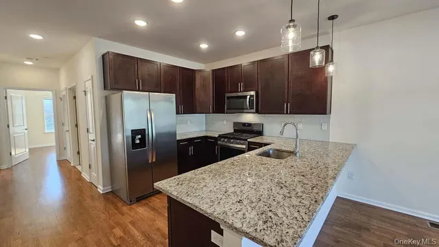 a kitchen with stainless steel appliances granite countertop a refrigerator and a sink