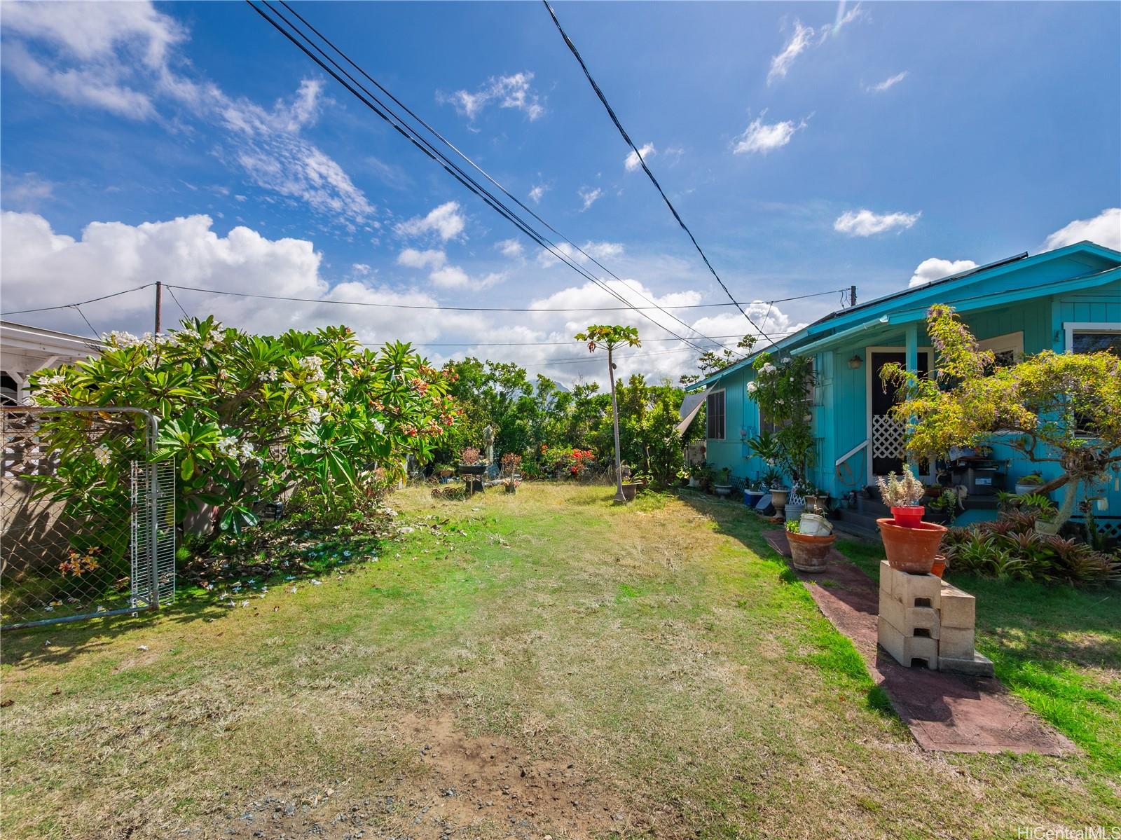 338 Manono Street, Unit B Kailua, HI 96734 - Photo 4 of 25 a view of a patio with table and chairs plants and wooden fence